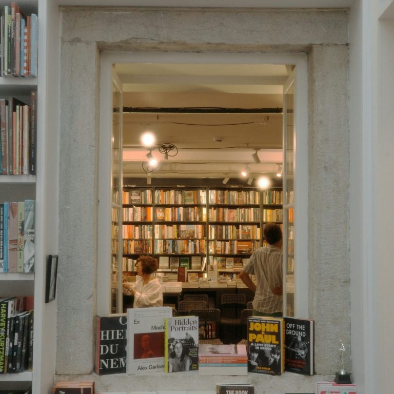 Social impact A man singing passionately into a microphone while wearing sunglasses and a vibrant hat.